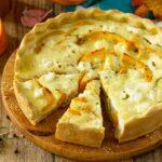 Classic Quiche Lorraine Pie with Pumpkin and Feta Cheese on a wooden table.