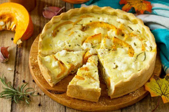 Classic Quiche Lorraine Pie with Pumpkin and Feta Cheese on a wooden table.