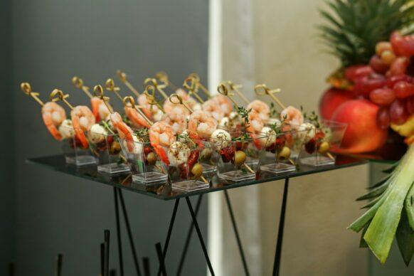 Food at event. Disposable plastic cups with snacks - shrimp with mozzarella cheese. Wedding event