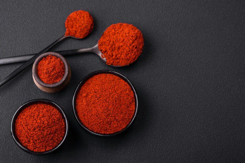 Spice smoked paprika in the form of powder in bowls and spoons