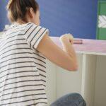 Young woman repainting old furnitures