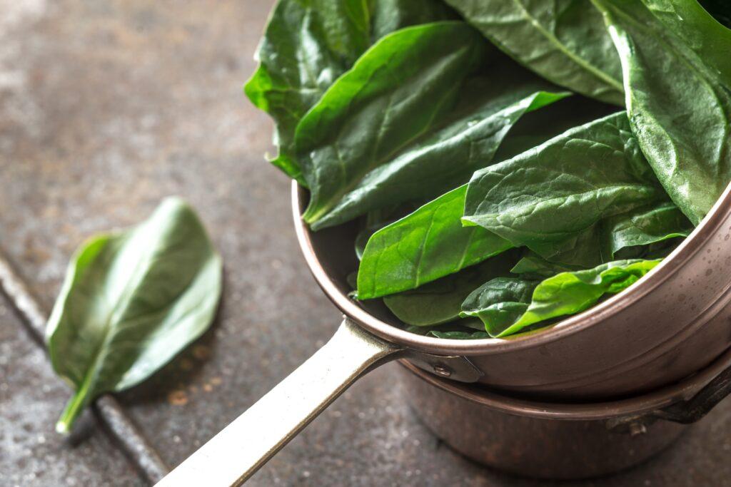 Fresh spinach in the copper pot